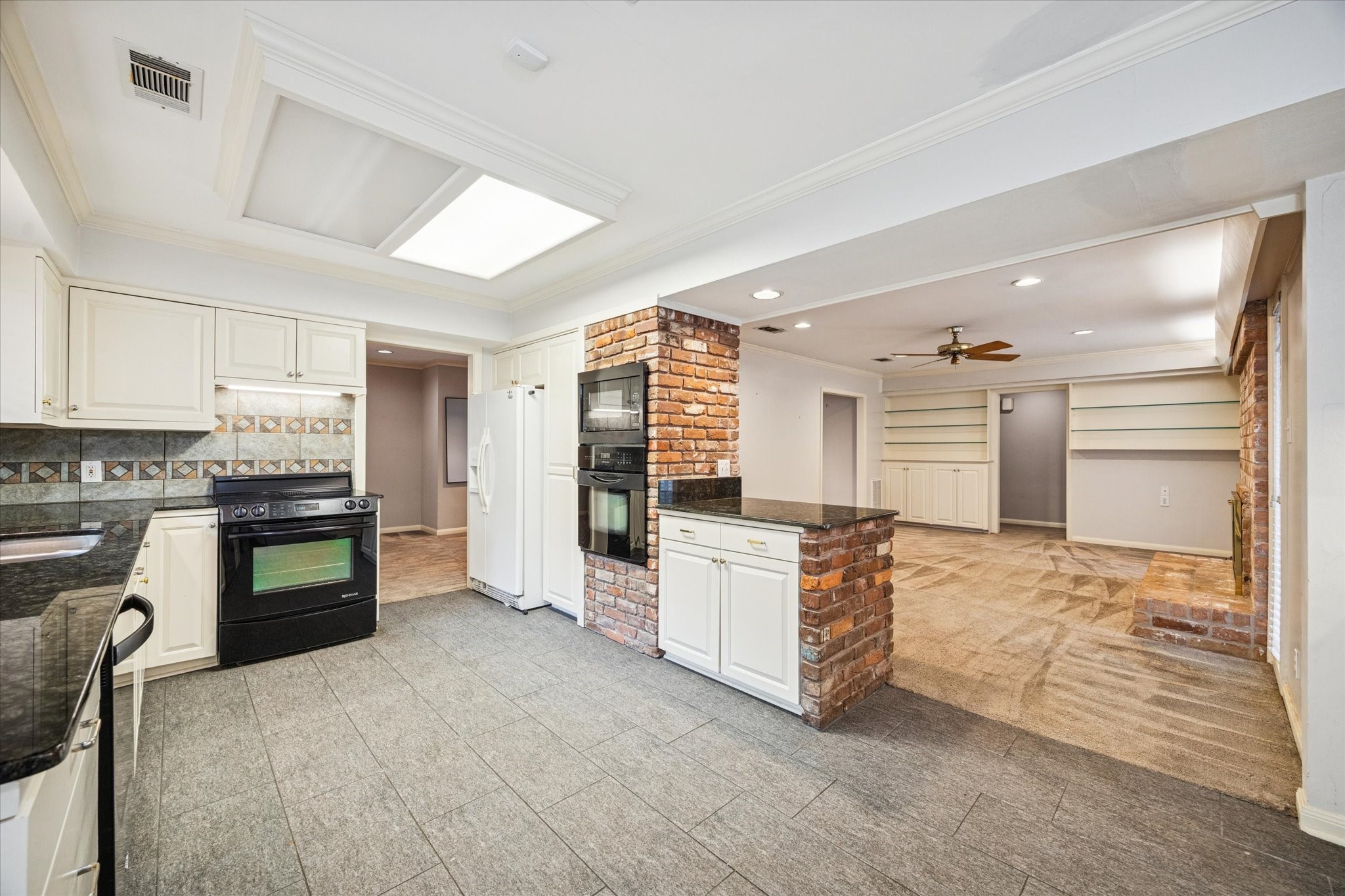 9022 Timberside Drive Houston, TX 77025 - Photo 4 of 10 a large white kitchen with stainless steel appliances granite countertop a stove and a refrigerator