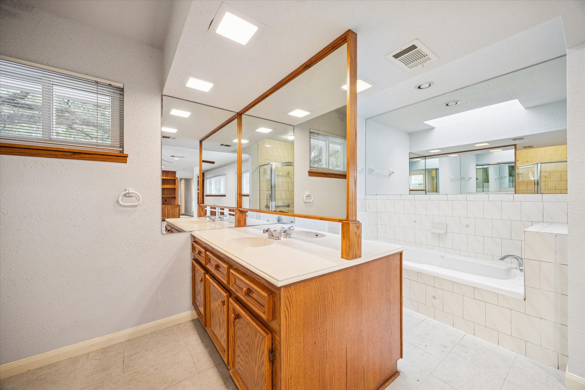 9022 Timberside Drive Houston, TX 77025 - Photo 7 of 10 a bathroom with a sink a mirror and a bathtub
