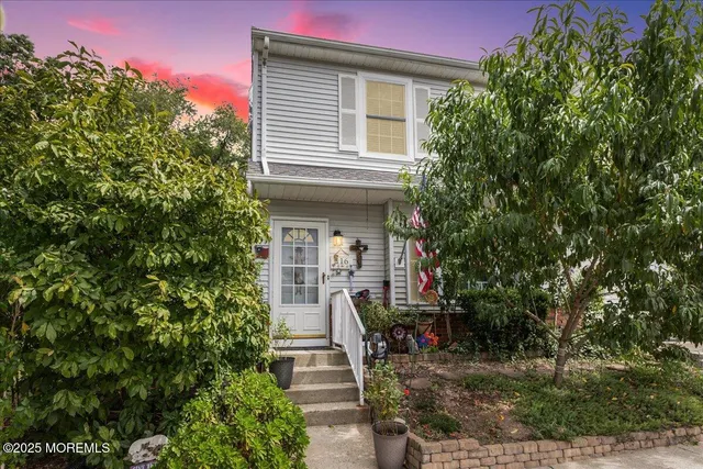 a view of a house with potted plants and a tree
