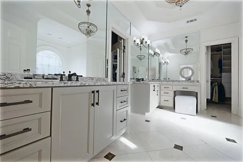a spacious bathroom with a granite countertop sink a mirror and a bathtub