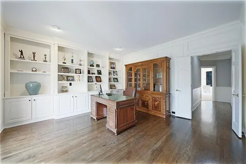 a living room with furniture a fireplace and a floor to ceiling window