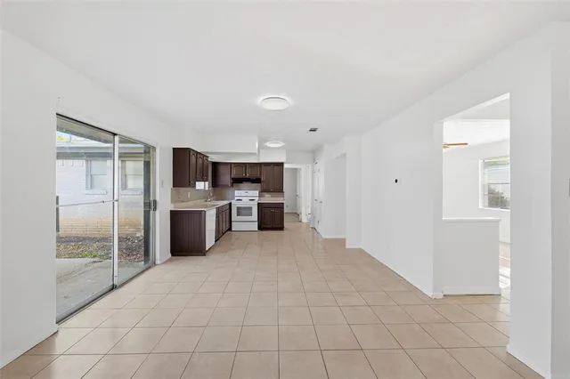 a large white kitchen with cabinets and a refrigerator