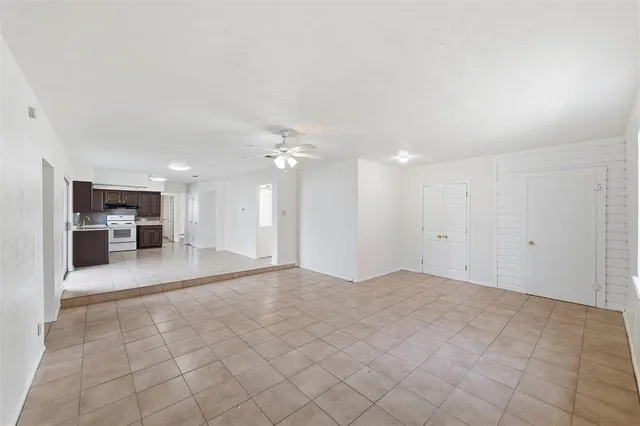 a large white kitchen with stainless steel appliances granite countertop a sink and cabinets