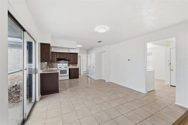 a large white kitchen with a stove a refrigerator and cabinets