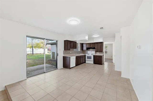 a large white kitchen with cabinets and a refrigerator