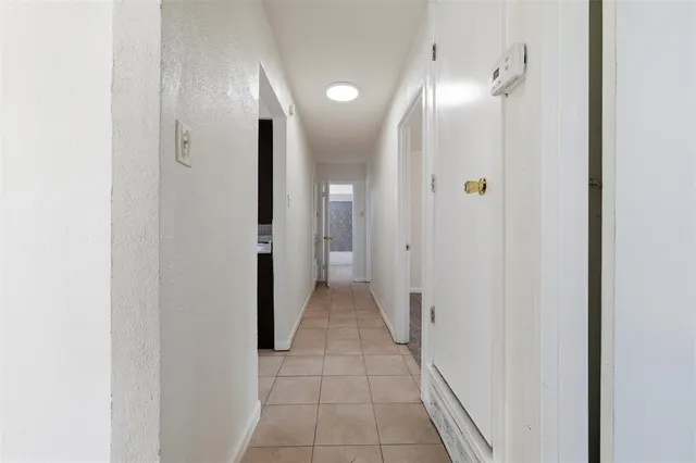 a view of a hallway with wooden floor and a bathroom