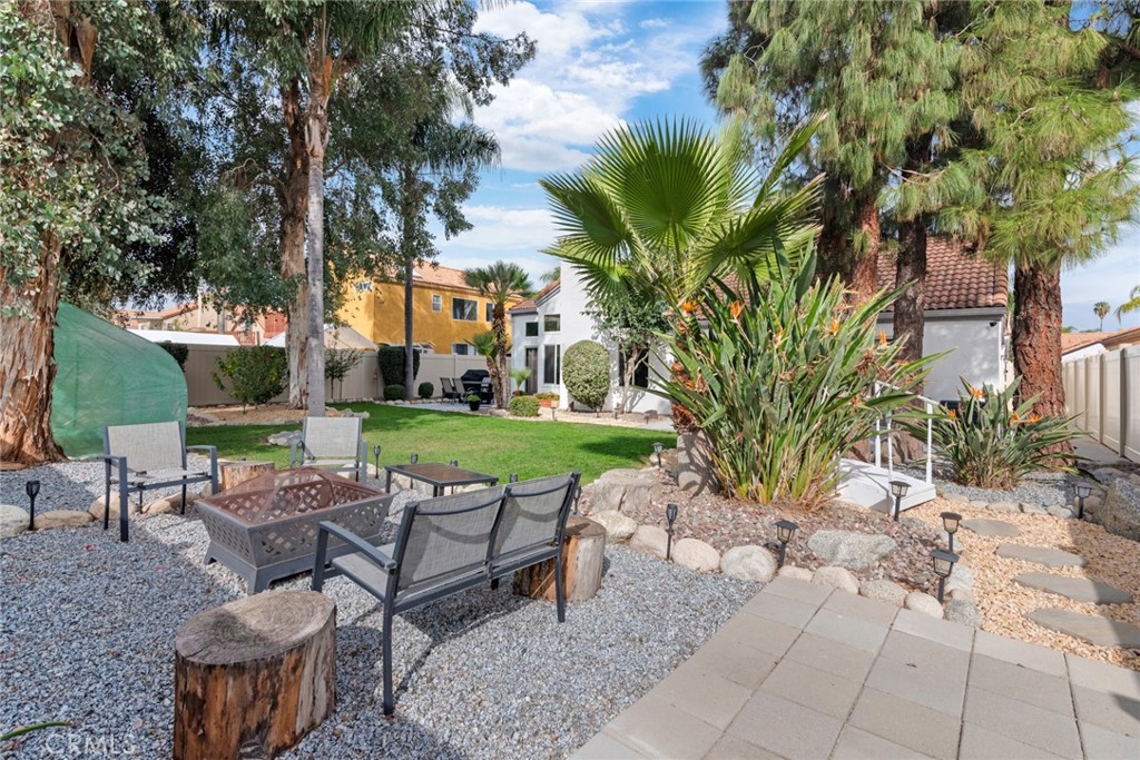 705 Fuchsia Lane Perris, CA 92571 - Photo 24 of 29 a view of a patio with table and chairs potted plants and palm trees