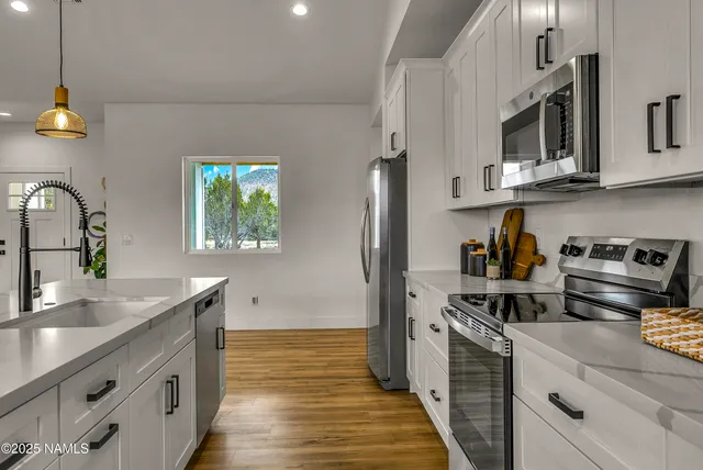 a kitchen with stainless steel appliances granite countertop a sink stove and refrigerator