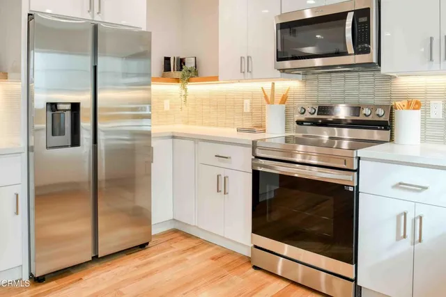 a kitchen with stainless steel appliances granite countertop a refrigerator and a stove top oven