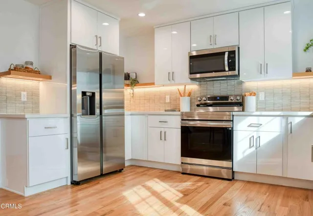 a kitchen with stainless steel appliances a refrigerator microwave and sink