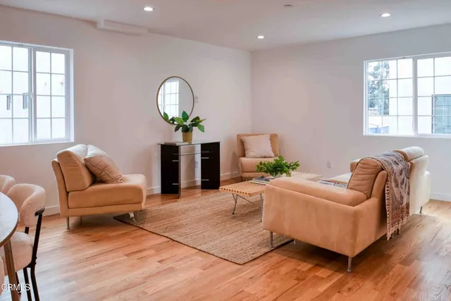 a living room with furniture a lamp and wooden floor