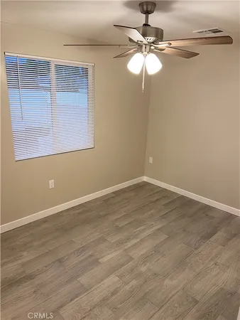 a view of a room with wooden floor fan and window