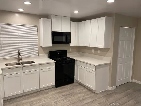 a kitchen with a sink and white cabinets