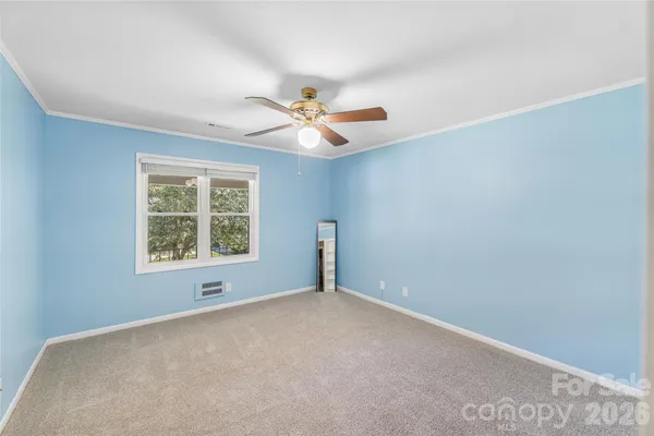 an empty room with a window and a ceiling fan