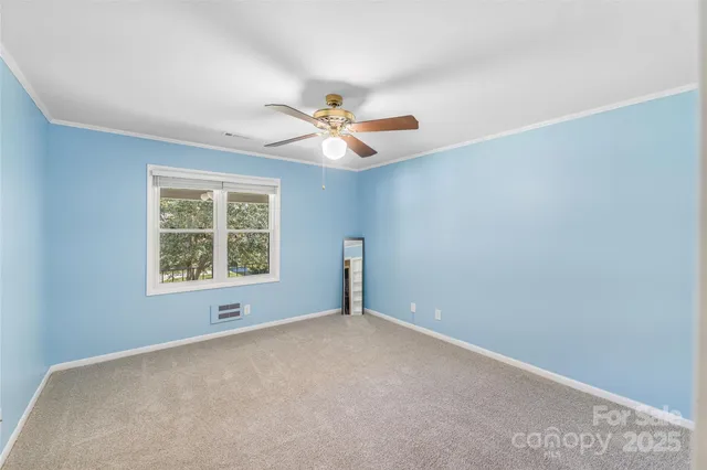 an empty room with a window and a ceiling fan