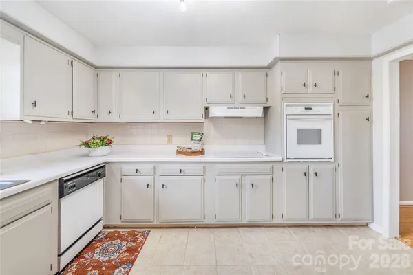 a kitchen with granite countertop white cabinets and stainless steel appliances