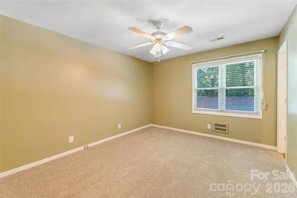 an empty room with a window and a ceiling fan