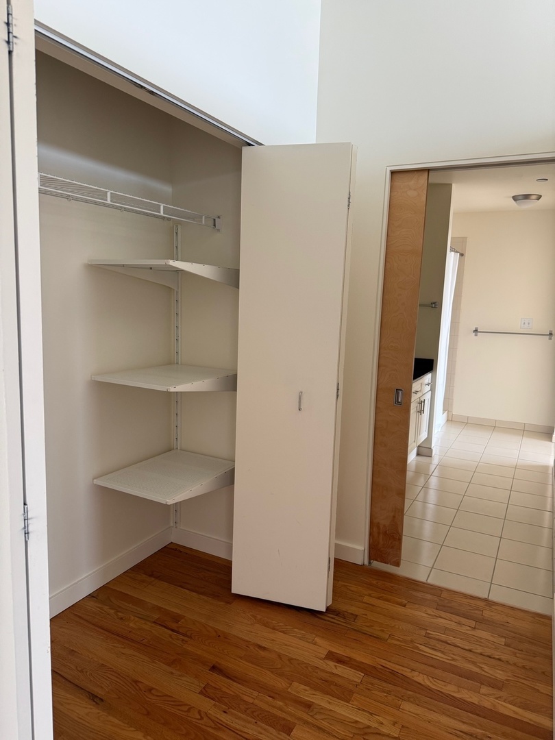 1720 South Michigan Avenue, Unit 2609 Chicago, IL 60616 - Photo 12 of 16 a view of an empty room with wooden floor and a window