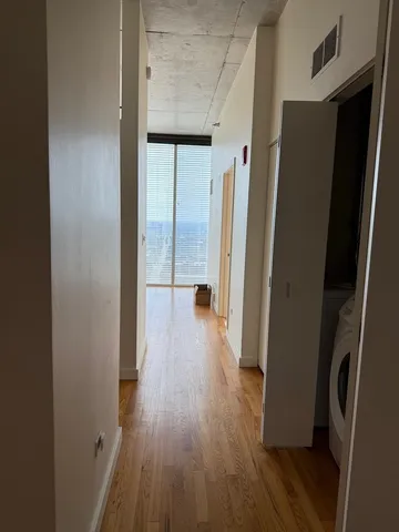 a view of hallway with wooden floor and stairs