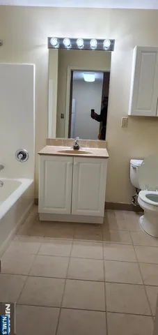 a bathroom with a bathtub sink and mirror