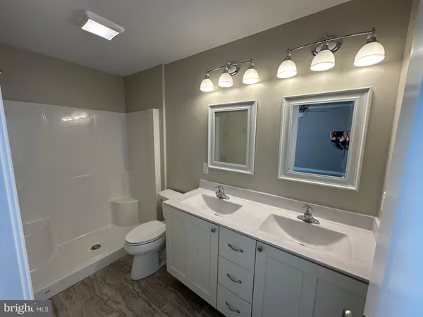 a bathroom with a toilet a sink and mirror