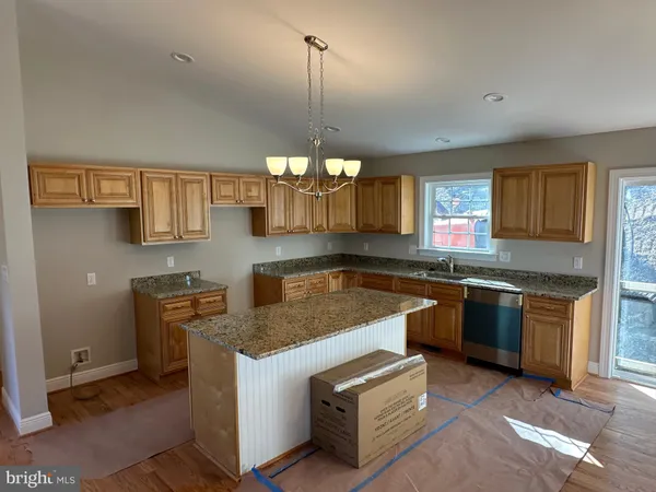 a kitchen with stainless steel appliances granite countertop a sink a stove and a wooden floors