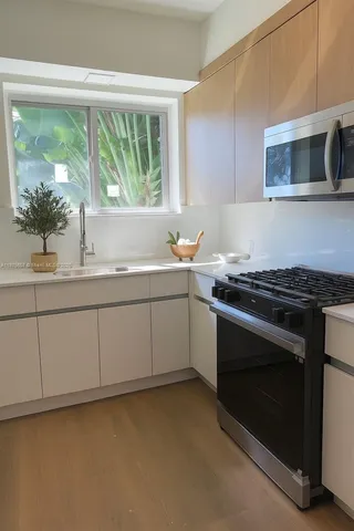 a kitchen with a sink stove and microwave