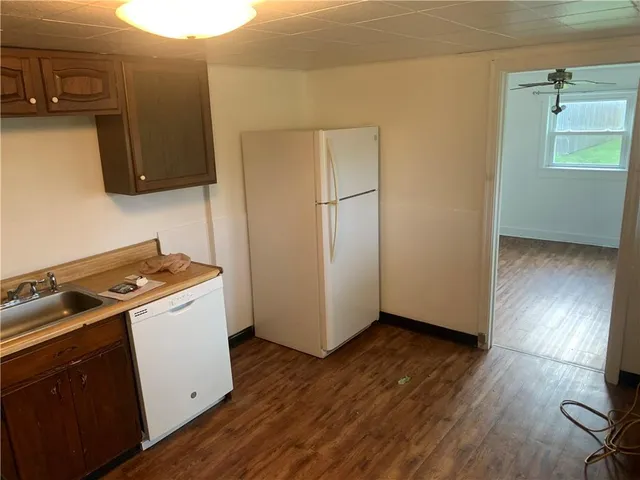 a view of a kitchen with wooden floor and electronic appliances