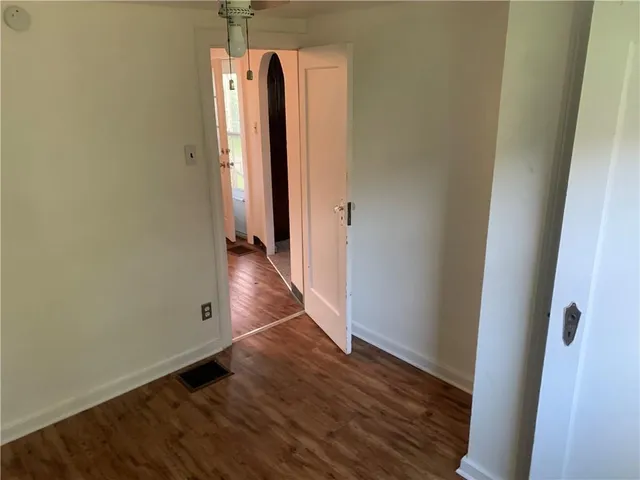 an empty room with wooden floor and closet