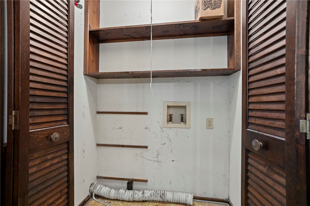 1022 Lakemont Road Starr, SC 29684 - Photo 13 of 24 Functional laundry hookups sit framed by classic louvered doors and overhead wood shelving.