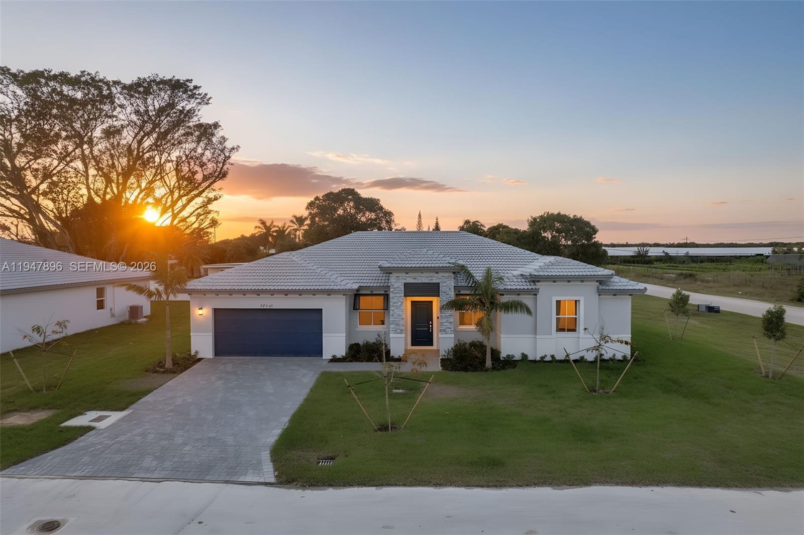 27210 Southwest 159th Path Homestead, FL 33031 - Photo 1 of 100 a front view of a house with a garden and lake view