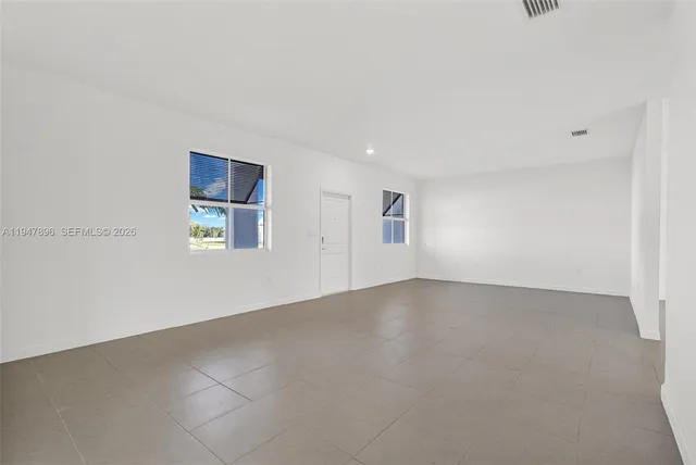a view of kitchen with kitchen island stainless steel appliances refrigerator sink and cabinets