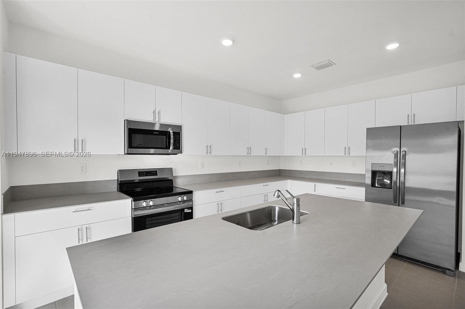 27210 Southwest 159th Path Homestead, FL 33031 - Photo 98 of 100 a kitchen with stainless steel appliances a stove a sink a microwave and cabinets