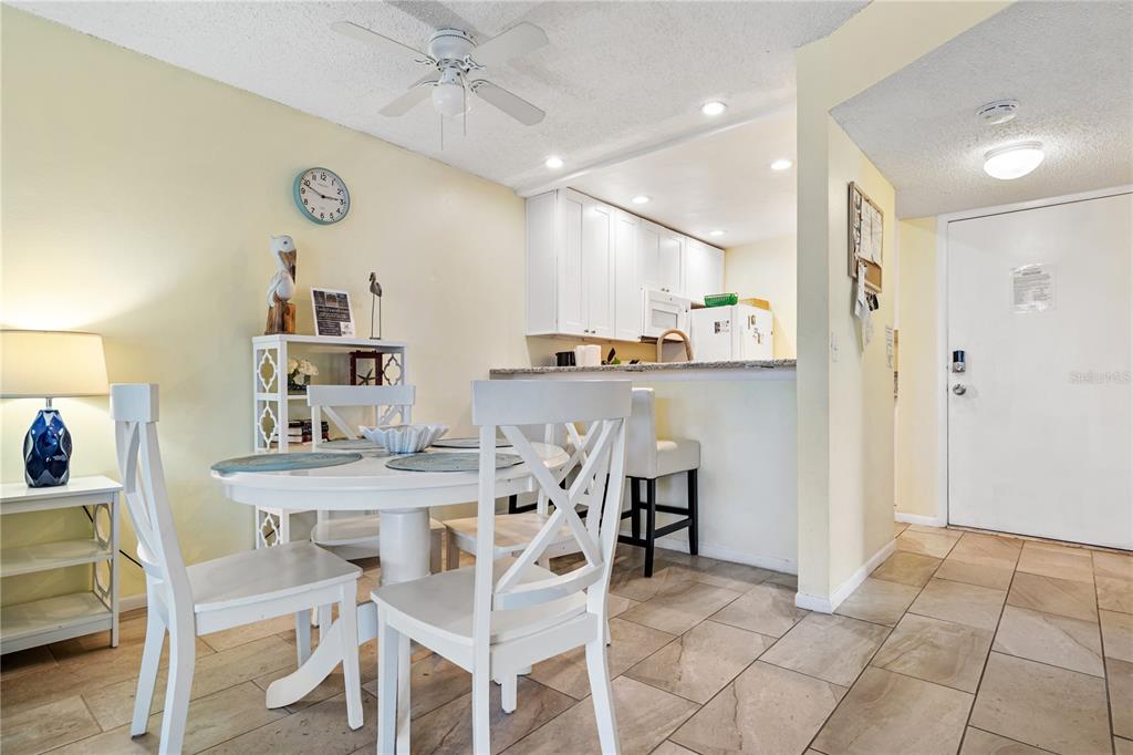 230 Medallion Boulevard, Unit E Madeira Beach, FL 33708 - Photo 7 of 35 a view of a dining room with furniture and wooden floor