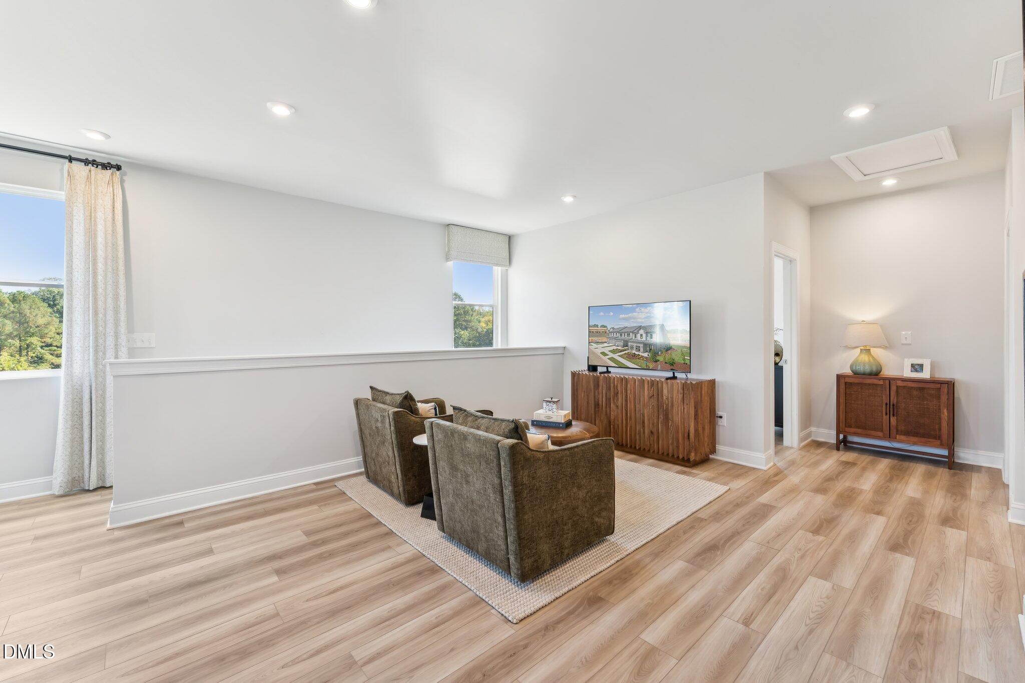 2124 Barrier Ridge Way Apex, NC 27502 - Photo 24 of 31 a living room with furniture and a wooden floor