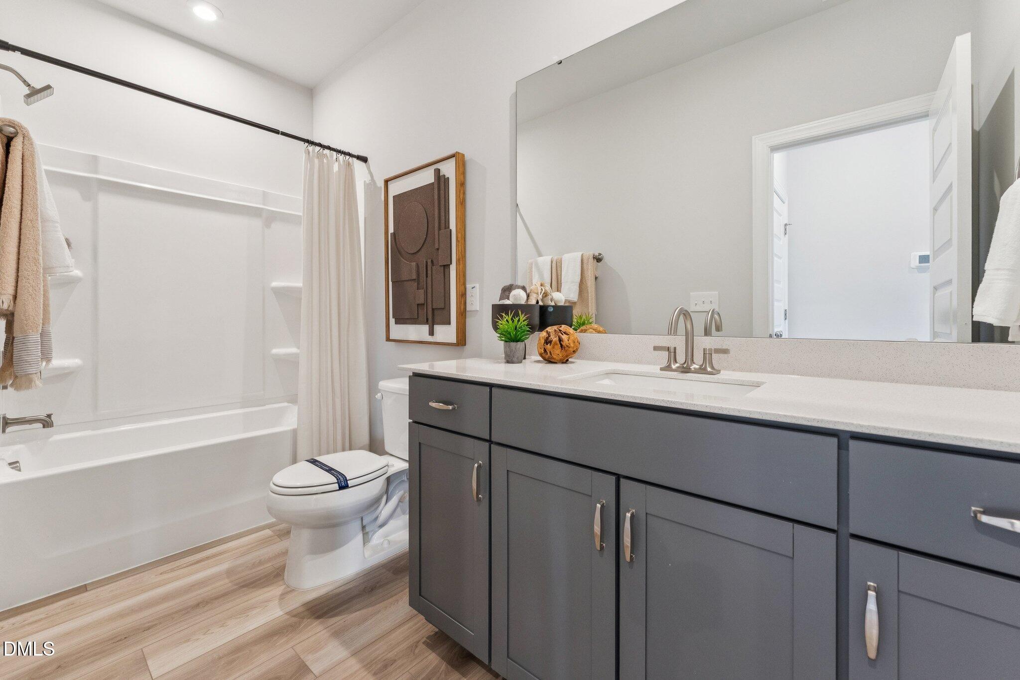 2124 Barrier Ridge Way Apex, NC 27502 - Photo 27 of 31 a bathroom with a sink toilet a mirror and shower
