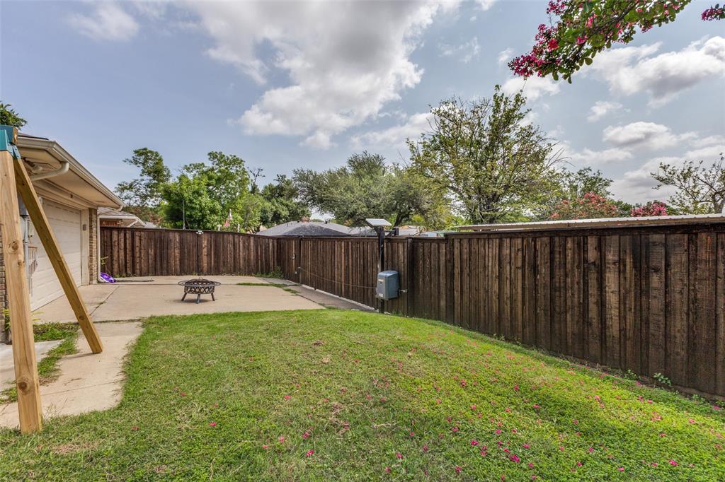 705 South Grove Road Richardson, TX 75081 - Photo 25 of 26 Private backyard featuring a concrete patio, fenced perimeter, and a sloped grassy area