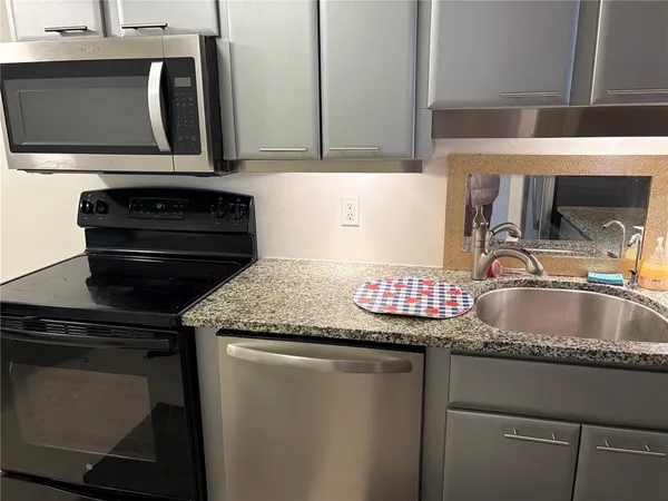 a kitchen with granite countertop a sink and a stove