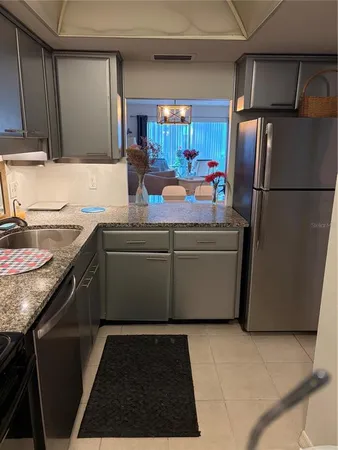 a kitchen with stainless steel appliances granite countertop a refrigerator and a sink