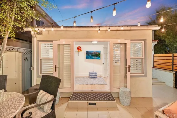 a view of a patio with couches table and chairs and potted plants