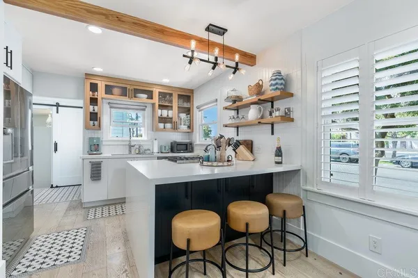 a kitchen with stainless steel appliances kitchen island granite countertop a table and chairs in it
