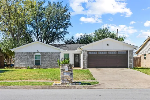 a front view of a house with a garden and garage
