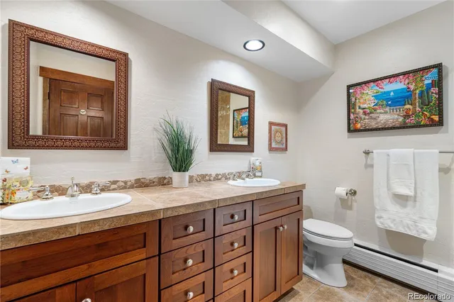 a bathroom with a toilet a sink a mirror and a shower