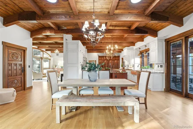 a view of a dining room with furniture a chandelier and wooden floor