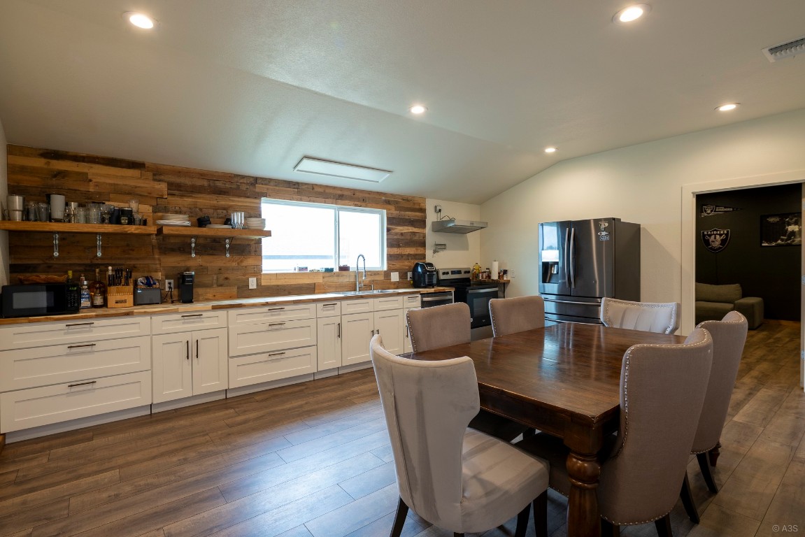 135 Wilbarger Bend Road Bastrop, TX 78602 - Photo 22 of 37 Dining room featuring dark wood-style flooring, lofted ceiling, visible vents, and recessed lighting