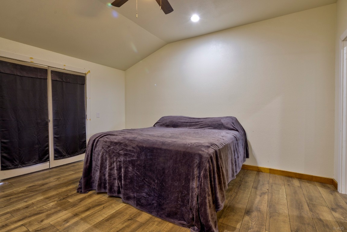 135 Wilbarger Bend Road Bastrop, TX 78602 - Photo 23 of 37 Bedroom with a ceiling fan, wood finished floors, recessed lighting, and vaulted ceiling