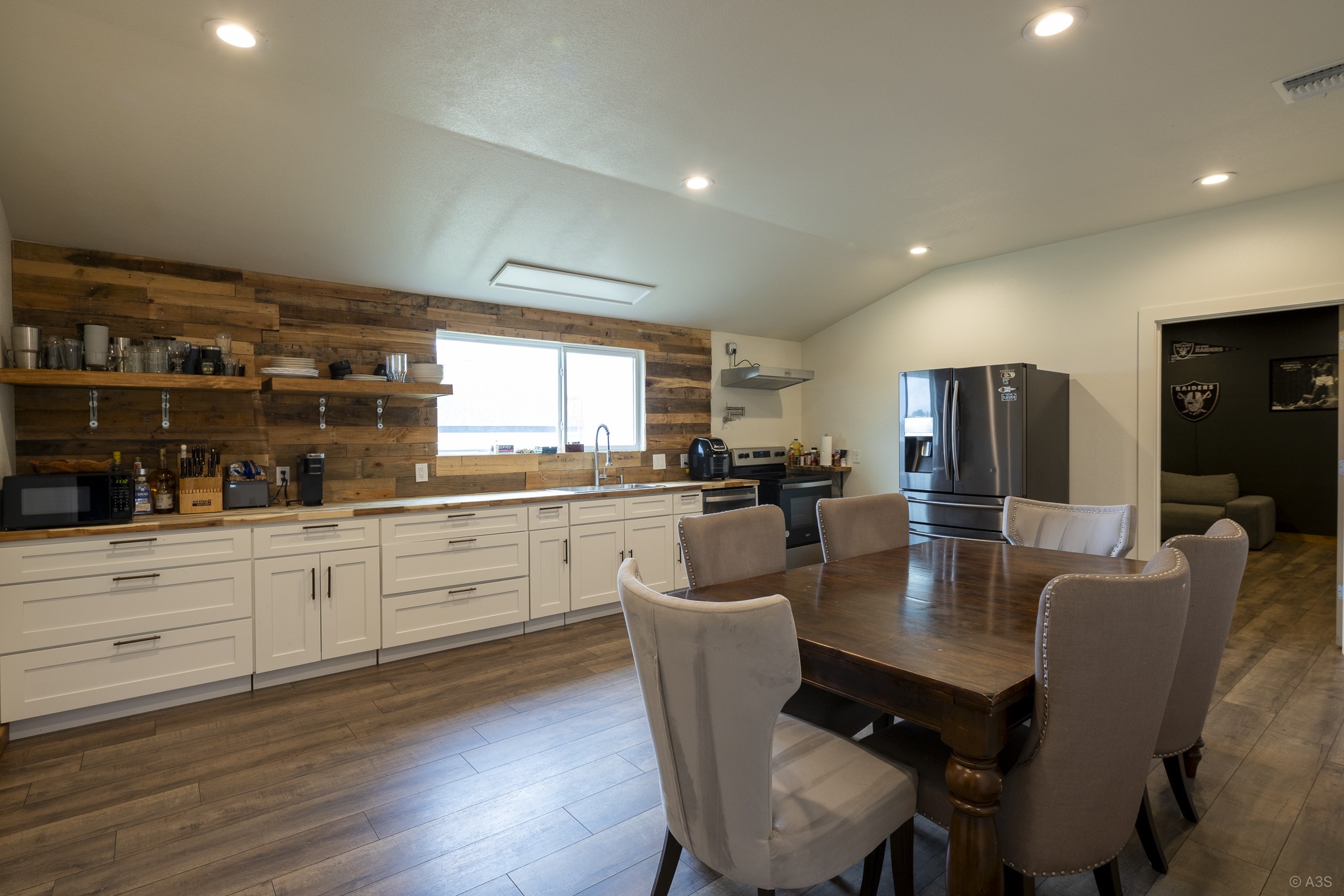 135 Wilbarger Bend Road Bastrop, TX 78602 - Photo 24 of 39 a large kitchen with dining table chairs and white cabinets