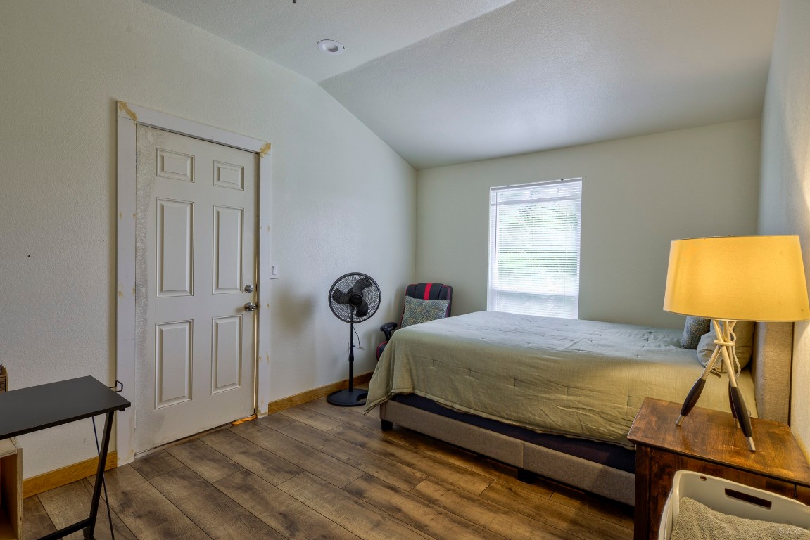 135 Wilbarger Bend Road Bastrop, TX 78602 - Photo 26 of 37 Bedroom with lofted ceiling, baseboards, and wood finished floors