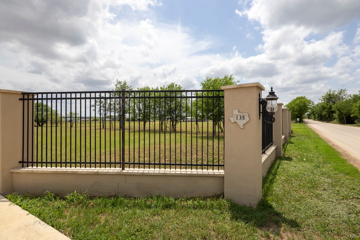 135 Wilbarger Bend Road Bastrop, TX 78602 - Photo 37 of 37 View of gate featuring a lawn and fence