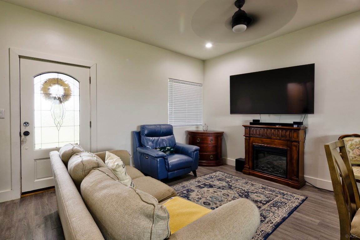 135 Wilbarger Bend Road Bastrop, TX 78602 - Photo 6 of 37 Living area with recessed lighting, a ceiling fan, a glass covered fireplace, and wood finished floors